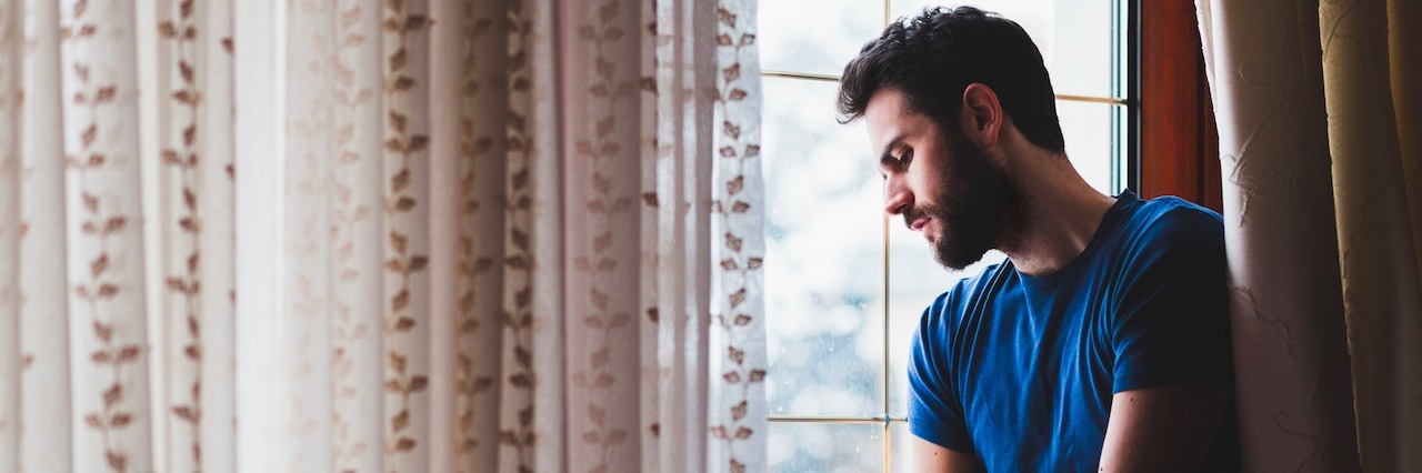 When an Employer Asked Me to 'Speed Up My Healing' From Depression Man looking out the window