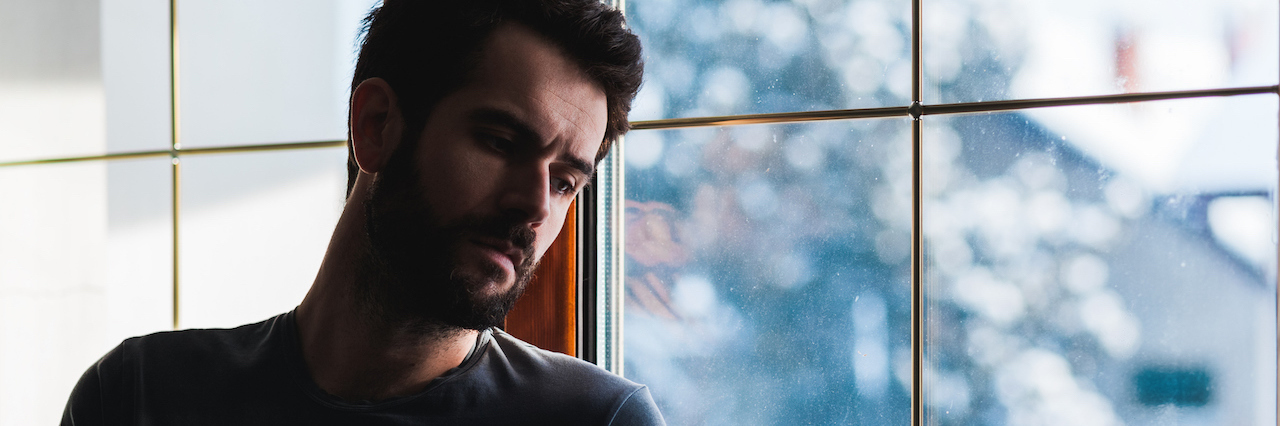 Borderline Personality Disorder and Self-Destruction A man standing by a window