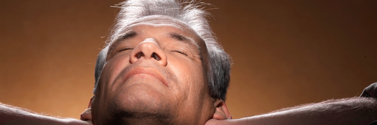 Managing 'Those' Hard Days With Bipolar Disorder, Depression & Anxiety Man stretching with hands on neck