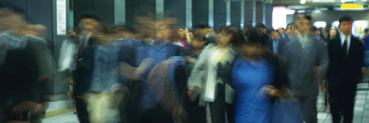 What Living With an Invisible Disability Looks Like People walking down passage in station, blurred motion, Tokyo, Japan
