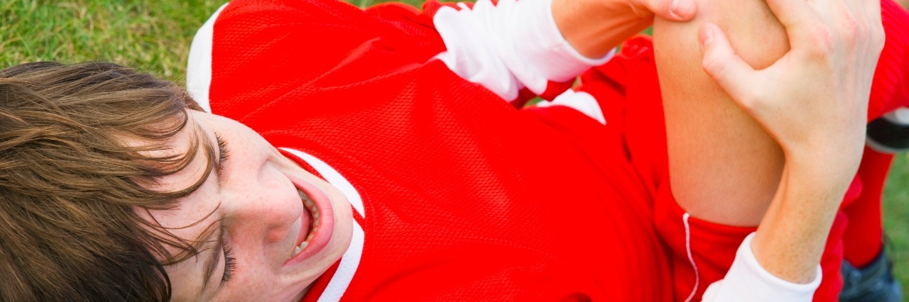 The Crossroads of Ehlers-Danlos Syndrome, Sports and Injury Boy lying on ground with hurt knee