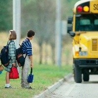 side profile of students standing in line for a school bus