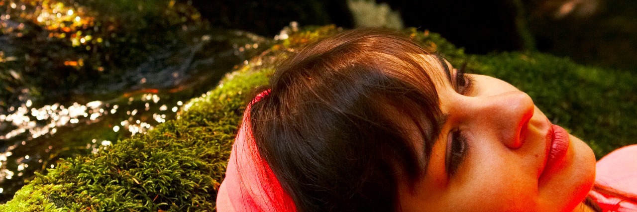 Young woman laying in forest