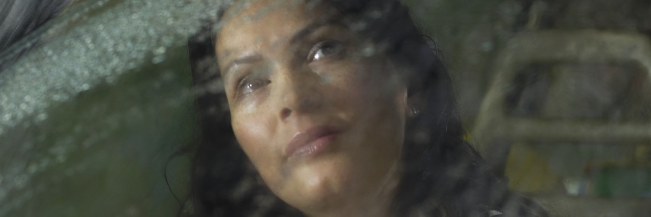 Woman looks out car window