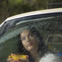 Woman looks out car window