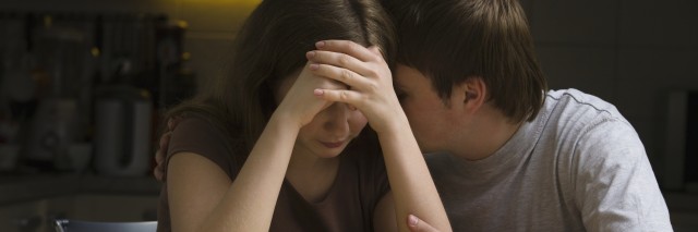 Serious young couple, woman with head in hands