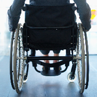 Woman sitting in a wheelchair in an office building.