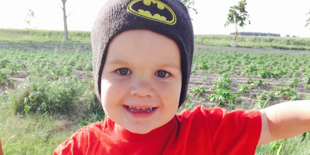 5 Tips for Managing Your Child's Food Allergies Abroad Little boy wearing a bright orange shirt that reads, "Alaska" and a batman beanie-hat on his head
