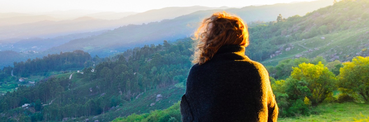 Why I'm Compassionate Towards Myself as Someone With Chronic Pain scenic view of woman watching at sunset mountains