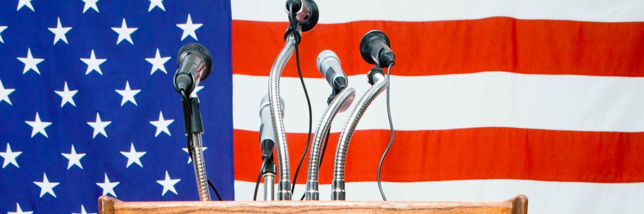 Podium with microphones by American flag