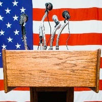 Podium with microphones by American flag