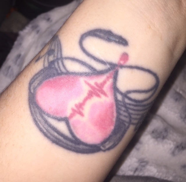 tattoo of heart with music notes and headphones around it