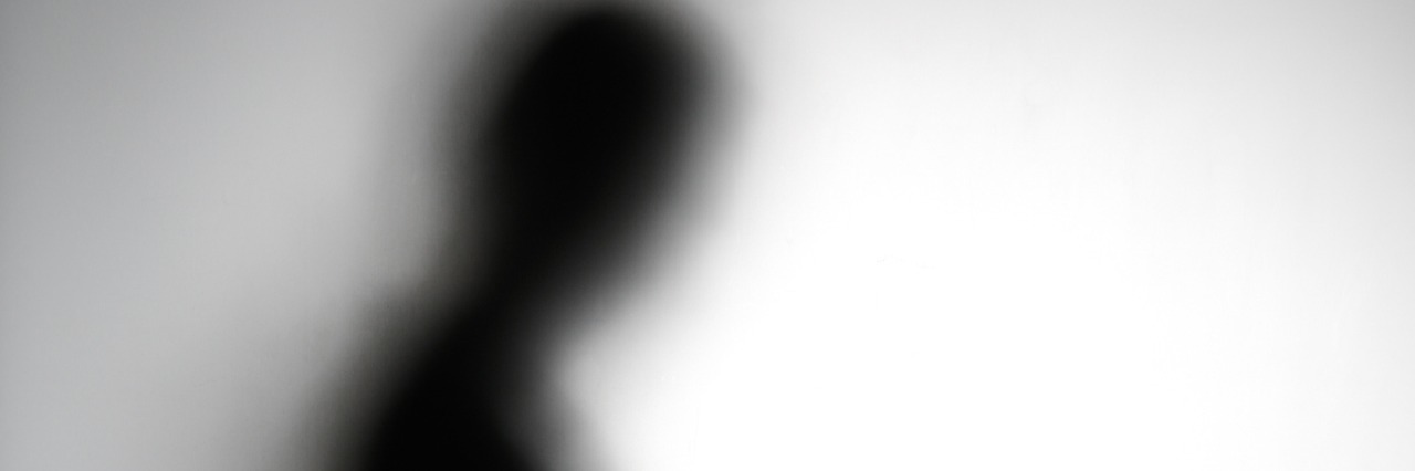 5 Things You Can't See About Living With Chronic Pain blurry shadow on gray background