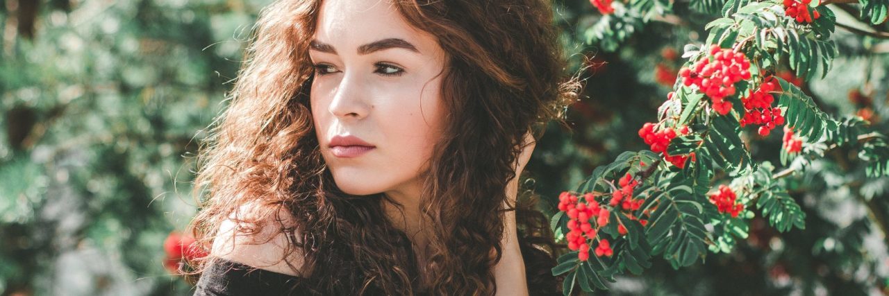My 2018 Goals, Not Resolutions, as a Person With Bipolar Disorder young contemplative woman in front of flowers