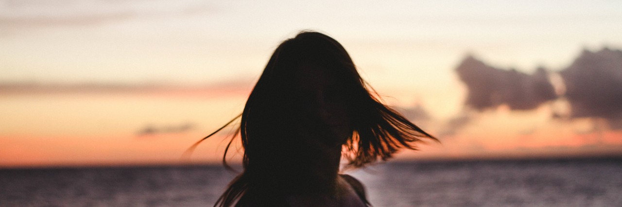 What It Means to 'Live With' PTSD woman twirling in the sunset