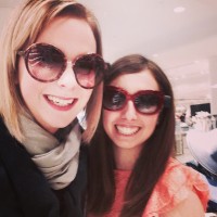 Two female friends wearing sunglasses, smiling at camera.