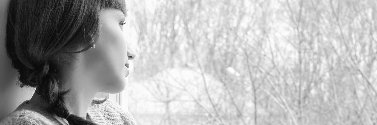 What to Know About Living With Rheumatoid Arthritis Young woman looking through window