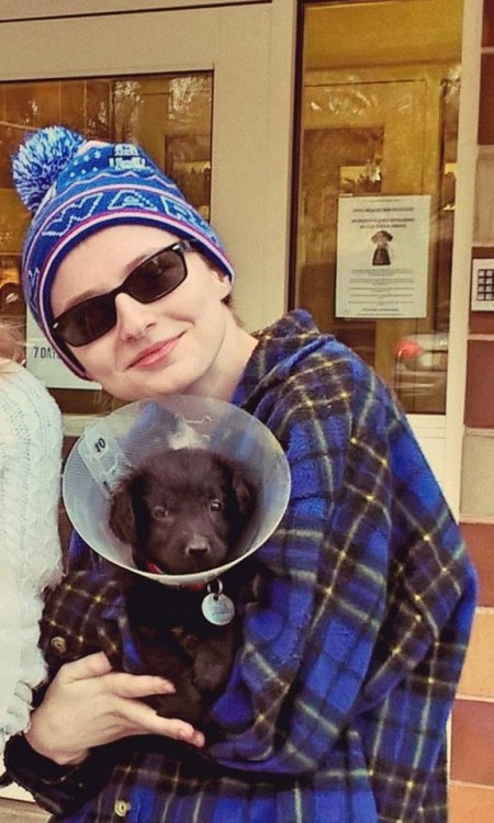 woman holding dog with cone on head