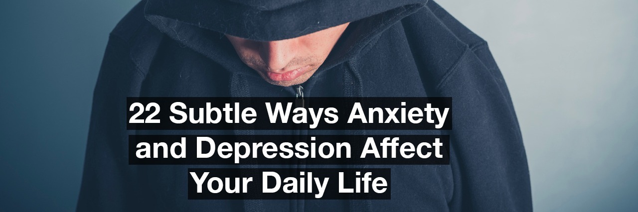 22 Subtle Ways Anxiety and Depression Affect Your Daily Life A young man is wearing a hooded top and is looking down. Text reads: 22 subtle ways anxiety and depression affect your daily life.