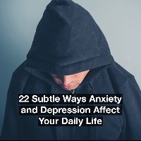 A young man is wearing a hooded top and is looking down. Text reads: 22 subtle ways anxiety and depression affect your daily life.
