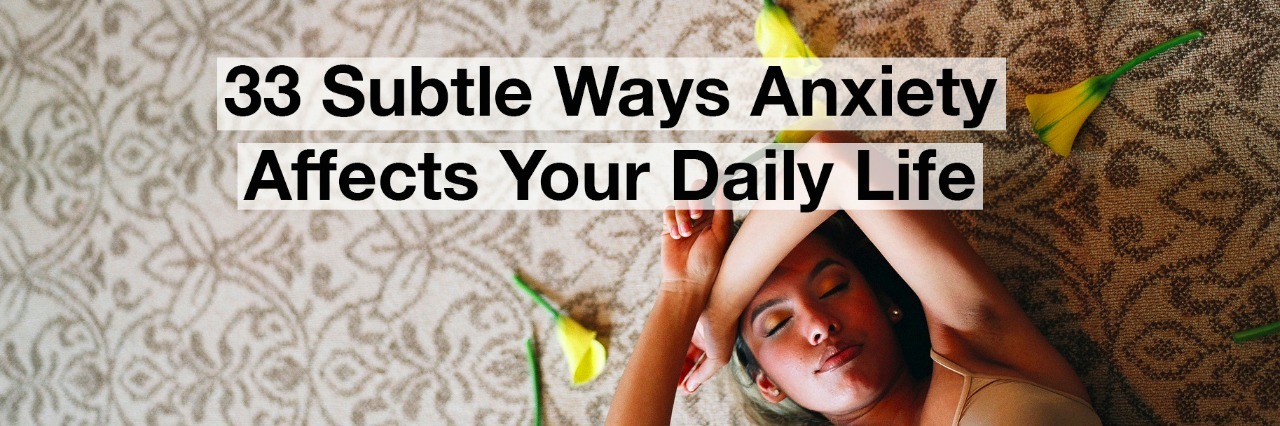 Woman lying with flowers. text reads: 33 subtle ways anxiety affects your daily life