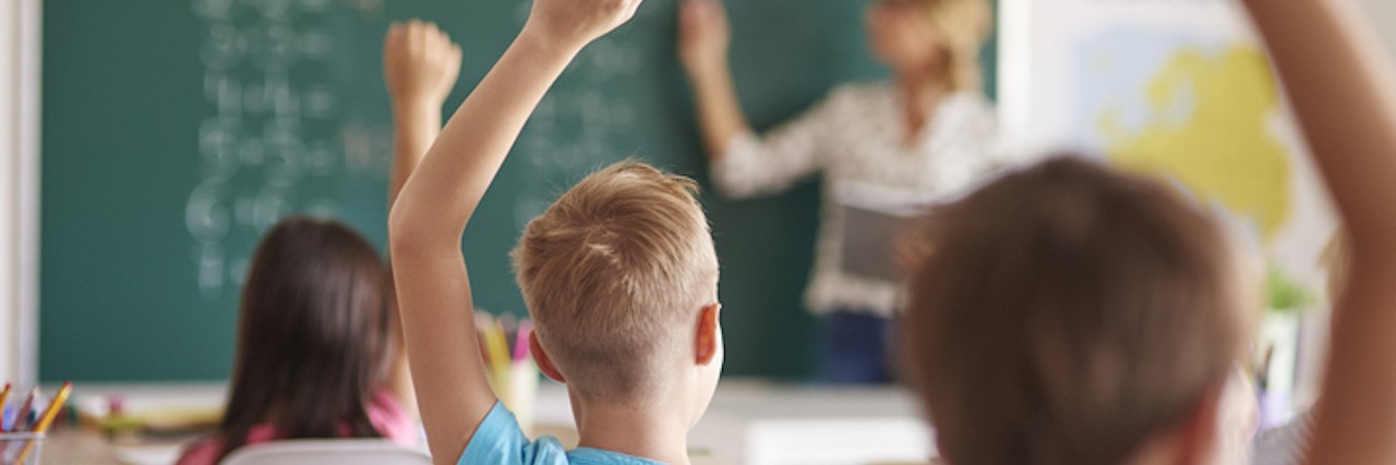 Tips for Teaching Students With PTSD, Anxiety or Other Trauma students in classroom with hands raised