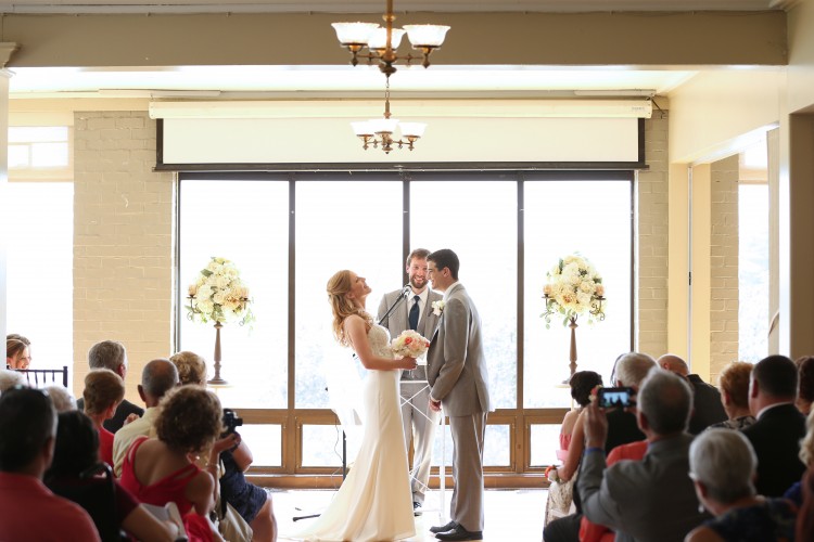 husband and wife standing at the altar getting married and laughing