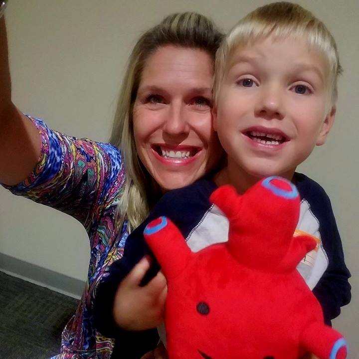 mom and son holding red stuffed heart