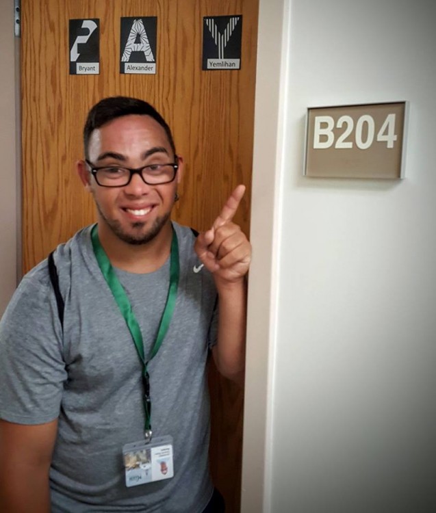 boy with down syndrome standing outside college dorm door