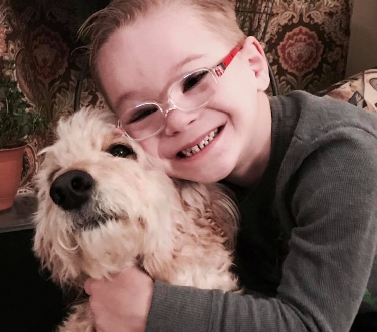 boy with down syndrome hugging dog