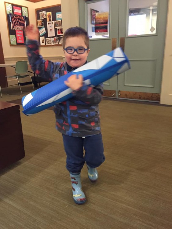 boy with down syndrome carrying yoga mat