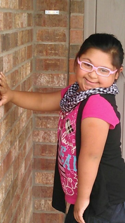 girl with down syndrome wearing pink glasses