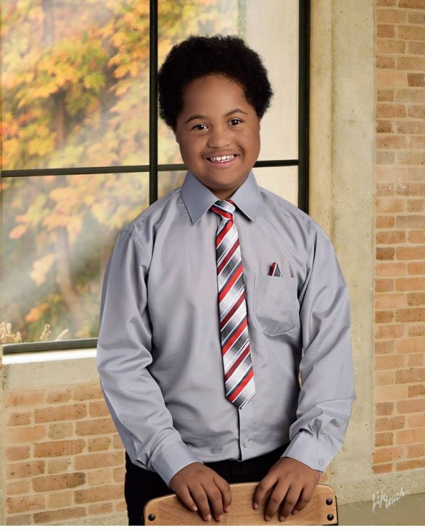 boy with down syndrome wearing a collared shirt and tie