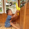 Little boy with Down syndrome playing with a yellow pirate wheel in a playset