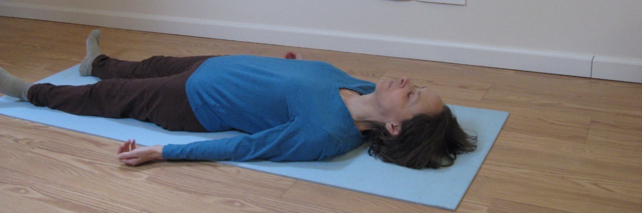 woman lying on yoga mat