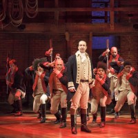 A shot of the musical with Alexander Hamilton at the front and ensemble in the back