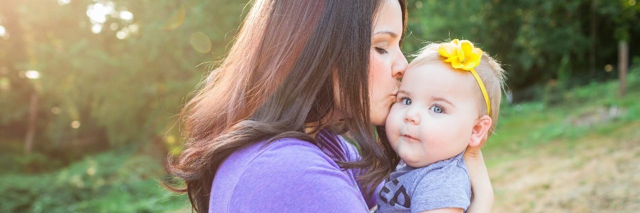 When People Say ‘I Don’t Know What to Say’ After My Daughter Died Mom holding baby daughter, kissing her cheek in front of a tree