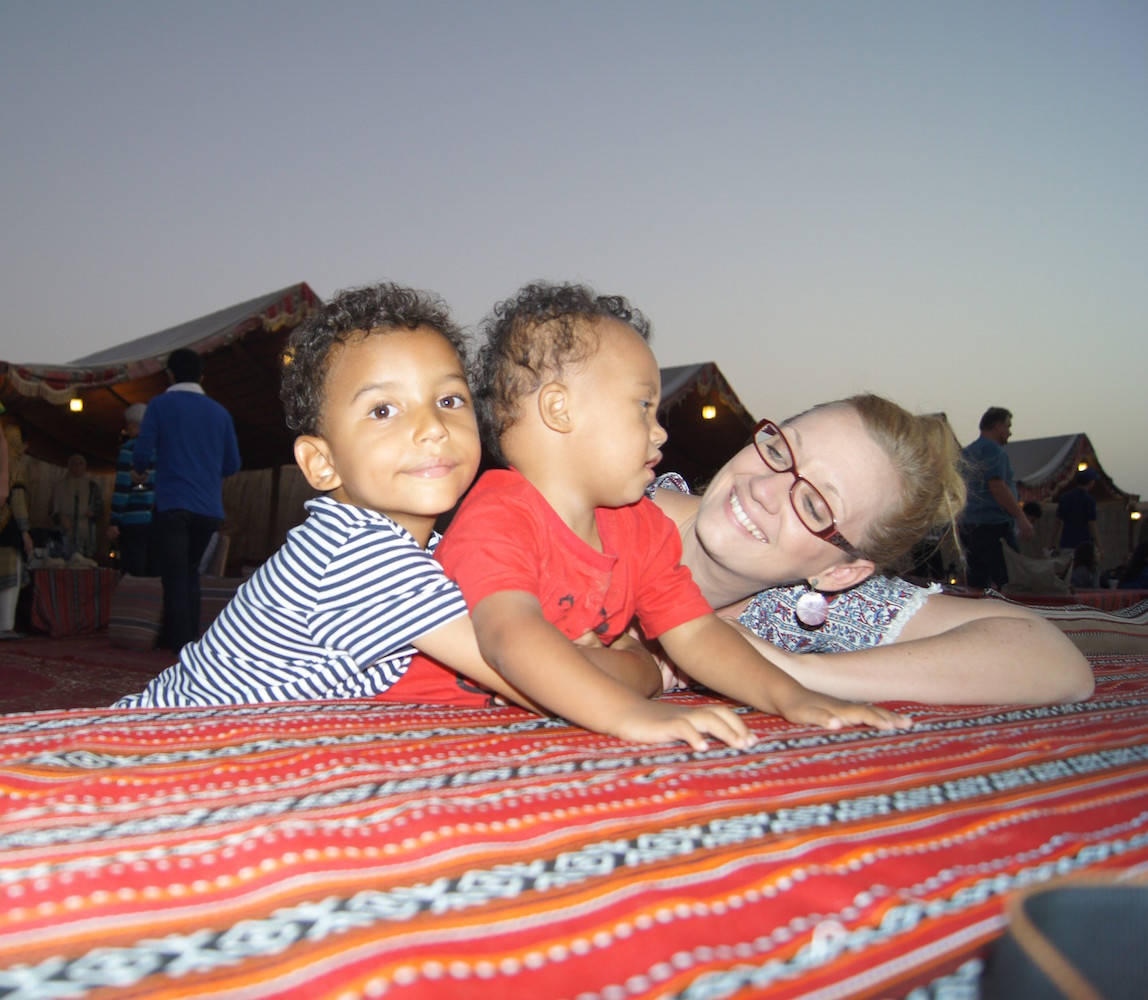 Mom with two sons, looking at sons and smiling