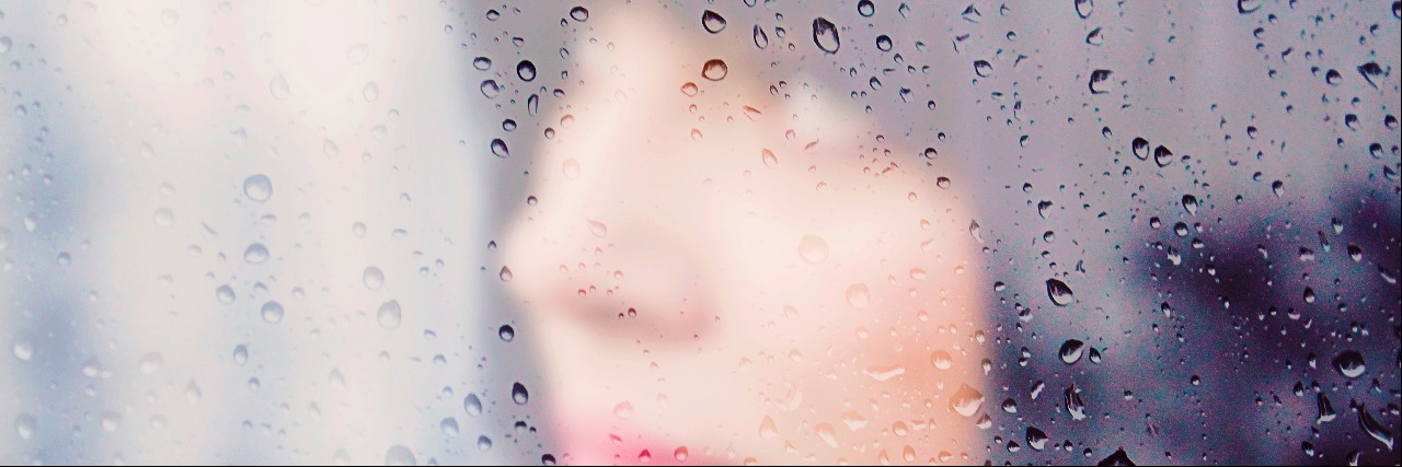 woman behind a rainy window