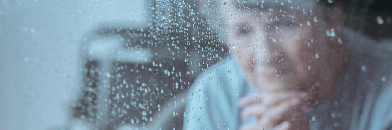 What It's Like to Have a Dying Parent A woman looking out a window