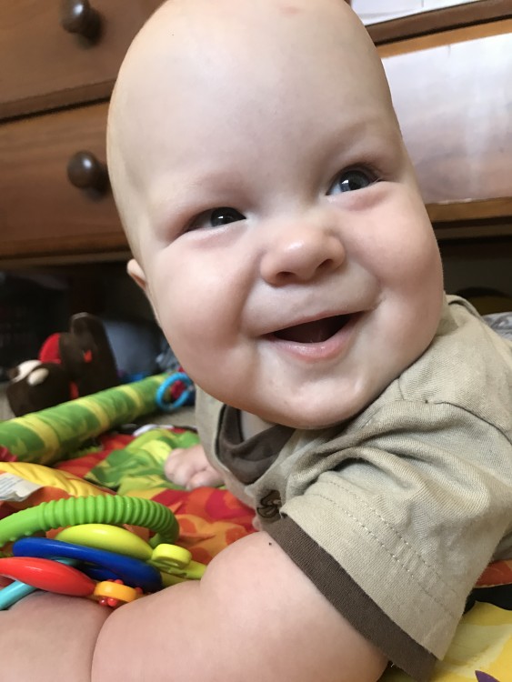 baby boy playing with toys and smiling