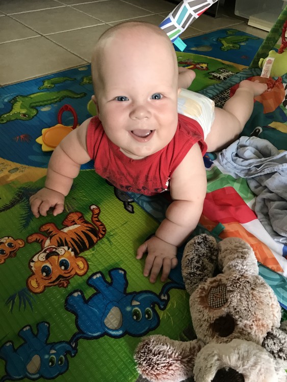 baby boy crawling on the floor and smiling