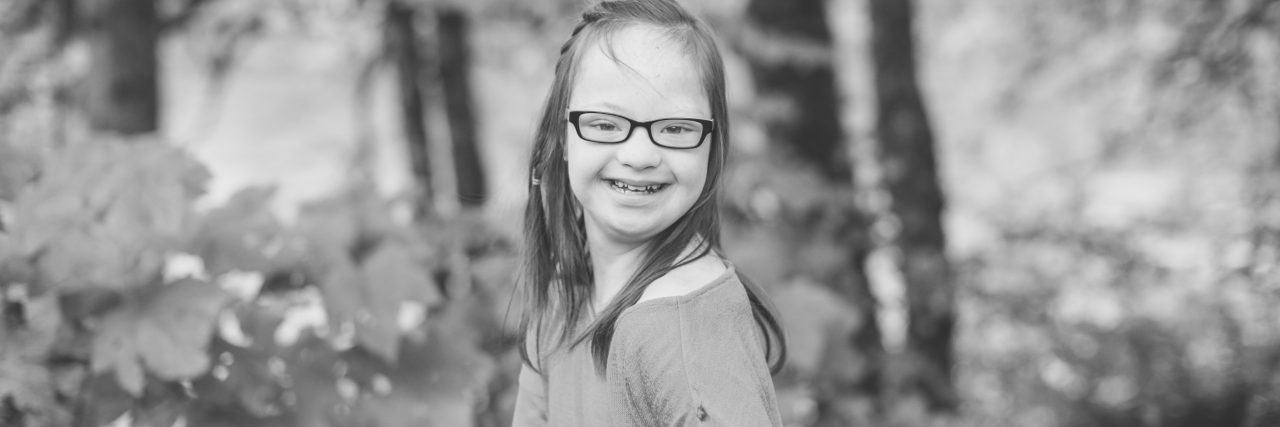 The Moments When I See How Far My Daughter With Down Syndrome Has Come girl smiling in the woods