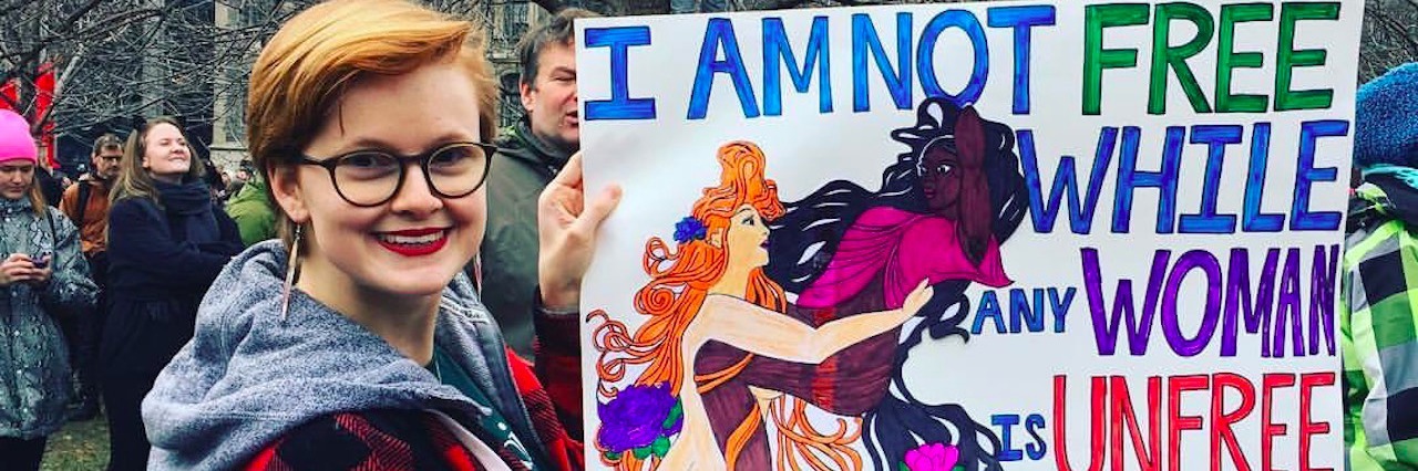 To the 3 Women Who Rallied For My Rare Disease at the Women's March woman carrying sign that says i am not free while any woman is unfree