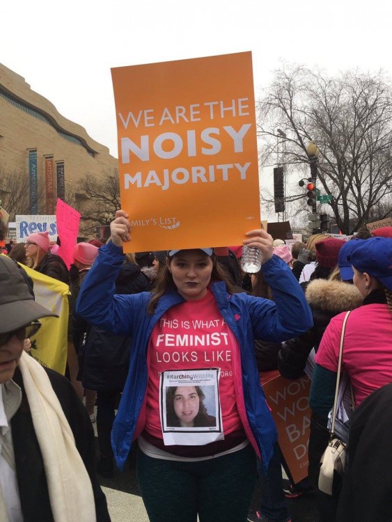 woman holding sign that says we are the noisy majority