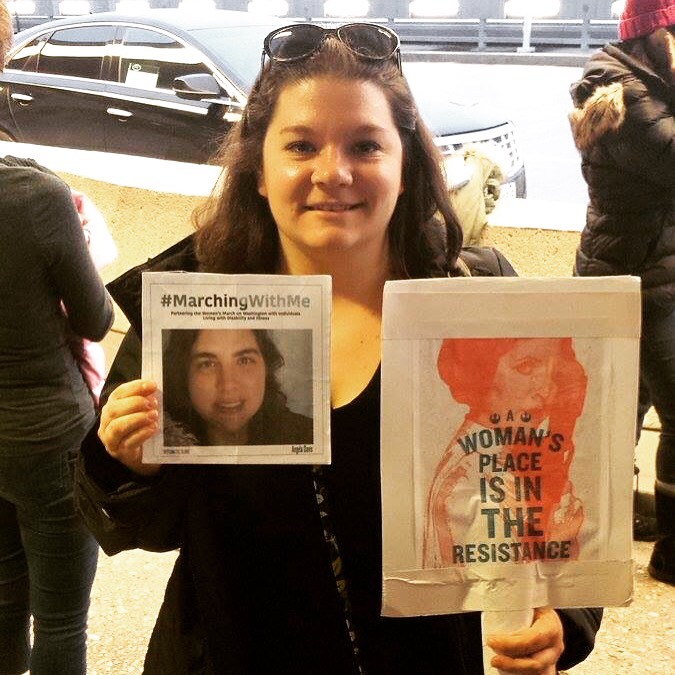 woman holding angela davis' marching with me sign and another sign that says a woman's place is in the resistance