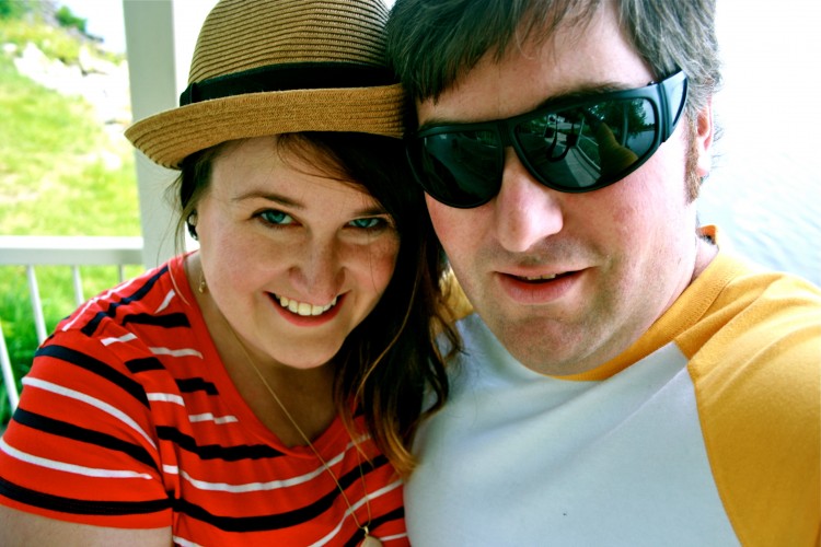 man in sunglasses and woman in a hat smiling