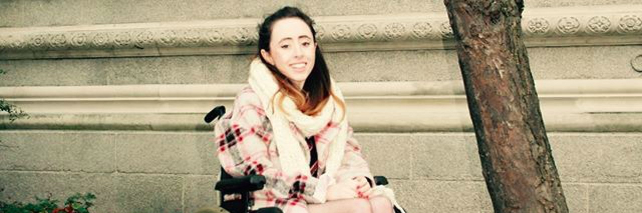 Niamh Herbert in a wheelchair outside.