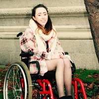 Niamh Herbert in a wheelchair outside.