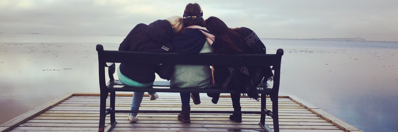 three women sitting on a bench